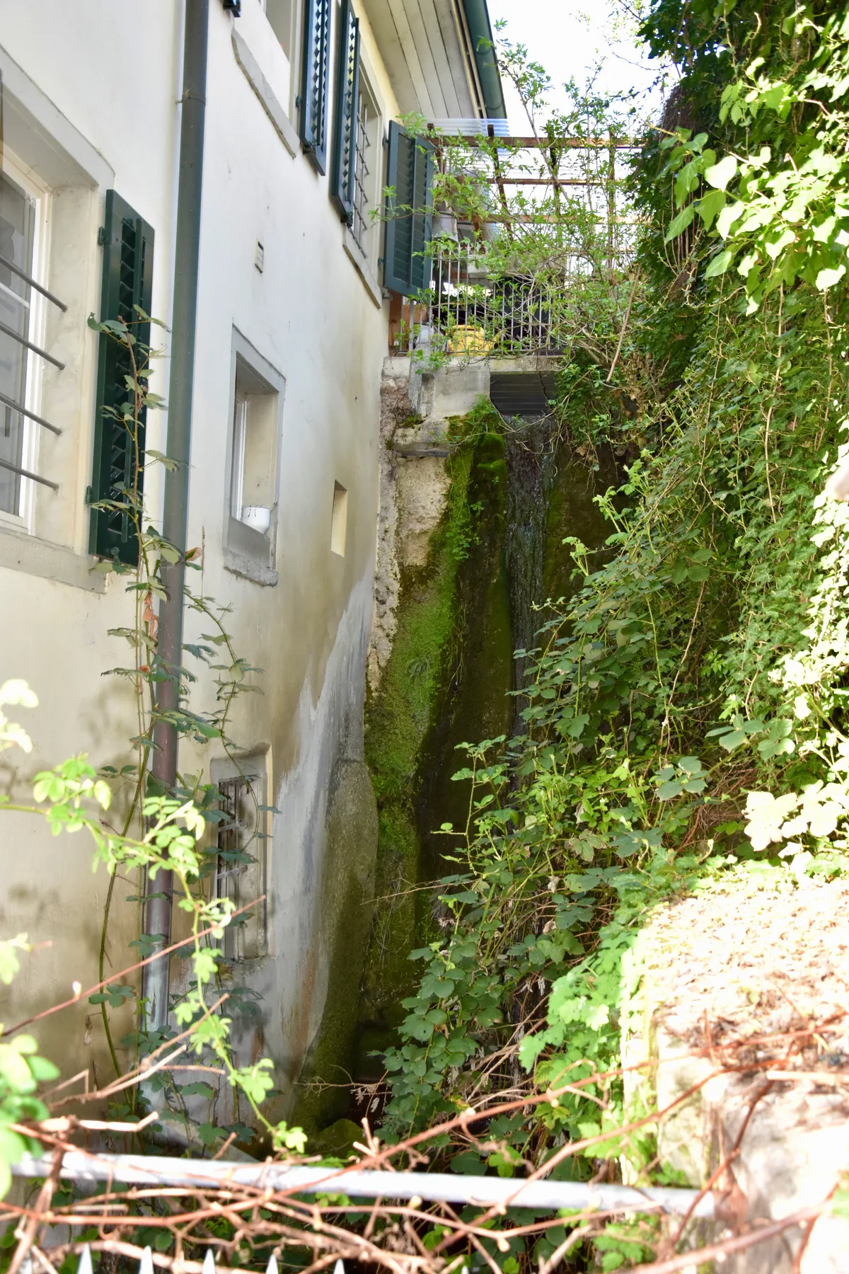 Hinter dem Haus Im Stock drehte sich einst ein Mühlrad. Eine Hauswand, an deren Seite einst ein Mühlrad war.